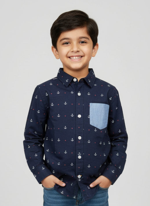Child wearing a navy blue shirt with anchor pattern and a blue pocket on a light gray background