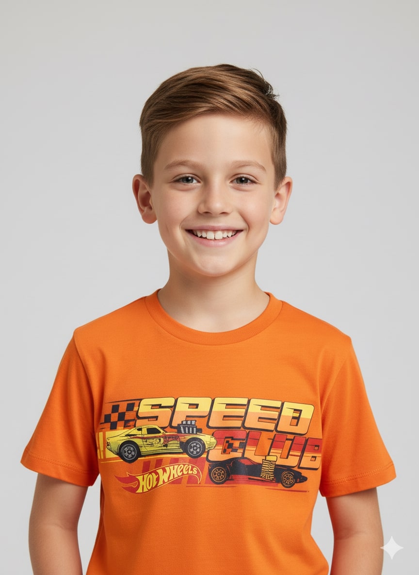 Child wearing an orange Hot Wheels t-shirt with a smile on a plain background