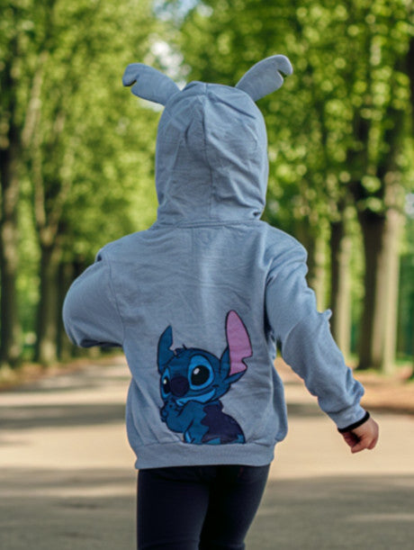 Person wearing a blue hoodie with cartoon character design outdoors
