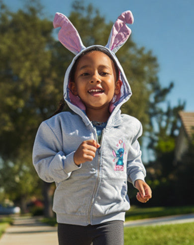Child wearing a light blue hoodie with bunny ears outdoors on a sunny day.